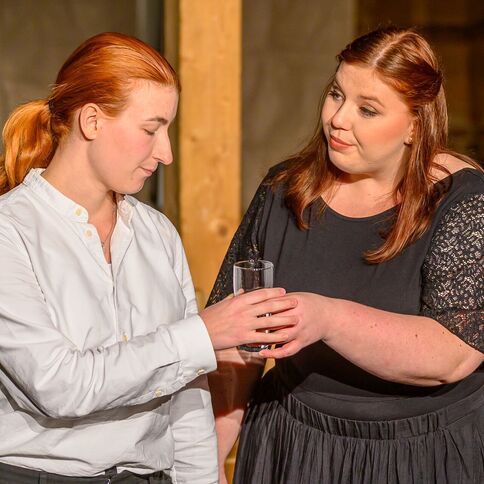 Zwei Frauen in einem Gespräch im Tuppenhof Kaarst, eine reicht der anderen ein Glas Wasser.