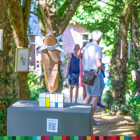 Im Tuppenhof in Kaarst bewundern Besucher eine kreative Skulptur in einer grünen, kunstvoll gestalteten Umgebung.