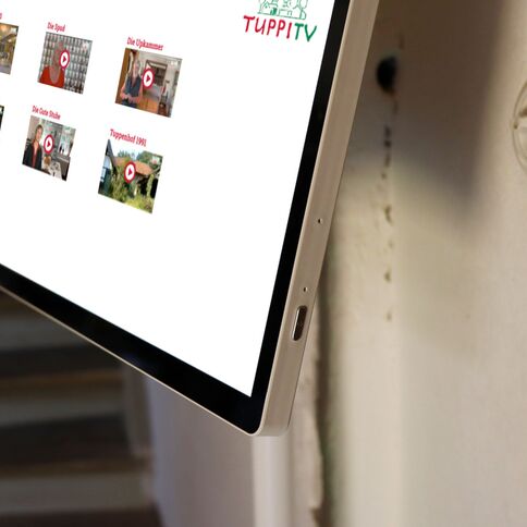 Ein Touchscreen-Display im Tuppenhof zeigt verschiedene Videos und Informationen für Besucher in Kaarst.