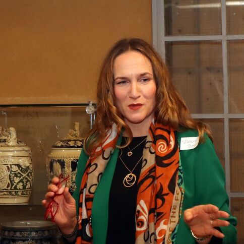 Eine Frau spricht im Tuppenhof in Kaarst vor einem Glasschrank, der mit aufwendiger Keramik dekoriert ist.