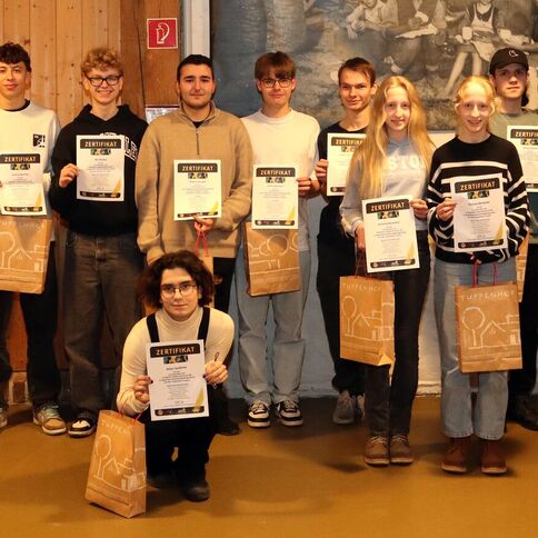 Eine Gruppe Jugendlicher posiert stolz mit Zertifikaten im Tuppenhof in Kaarst für ein Foto.