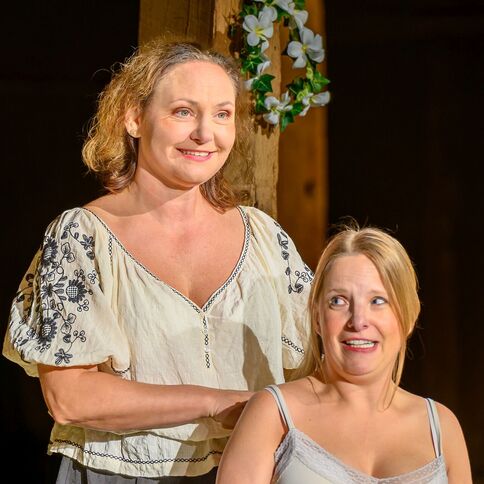 Zwei lachende Frauen in traditioneller Kleidung genießen einen Moment im Tuppenhof in Kaarst.