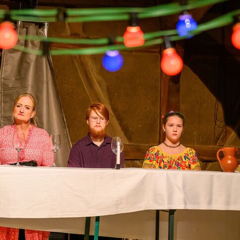 Vier Personen sitzen in bunter Dekoration an einem Tisch im Tuppenhof in Kaarst.