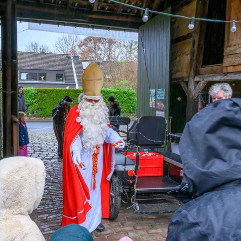 Ein Nikolaus verteilt auf dem Tuppenhof in Kaarst Süßigkeiten an eine Gruppe von Kindern.