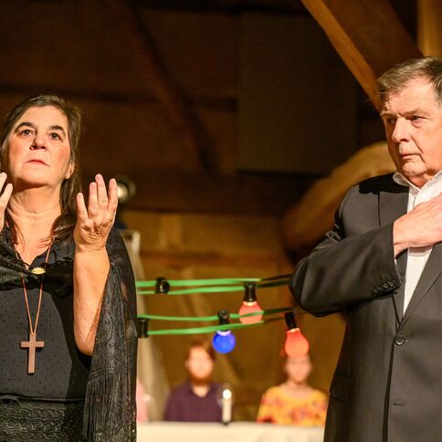 Zwei Personen führen ein emotionales Theaterstück im Tuppenhof in Kaarst auf, umgeben von bunten Lichtern.