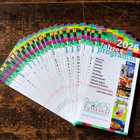 Ein fächerartig angeordnetes Jahresprogramm 2026 des Tuppenhofs in Kaarst zeigt verschiedene Veranstaltungen und Workshops.