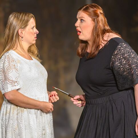 Zwei Frauen stehen auf einer Bühne im Tuppenhof, Kaarst, und führen ein emotionales Gespräch mit intensiven Gesten.