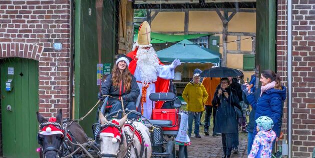 Ein fröhlicher Nikolaus auf einer Kutsche grüßt Besucher beim Tuppenhof in Kaarst.
