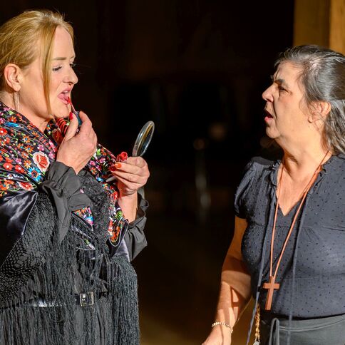 Zwei Frauen stehen im Tuppenhof in Kaarst, eine trägt Lippenstift auf, während die andere überrascht schaut.