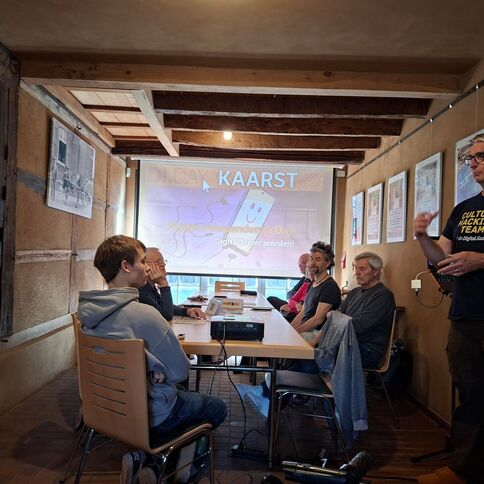 Eine Gruppe von Menschen sitzt in einem Raum im Tuppenhof in Kaarst und hört einem Vortrag zu digitaler Transformation zu.