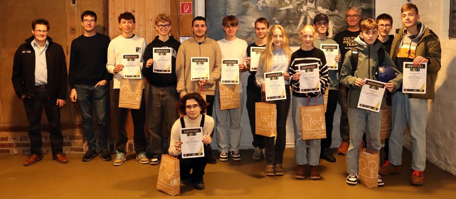 Eine Gruppe Jugendlicher posiert stolz mit Zertifikaten im Tuppenhof in Kaarst für ein Foto.