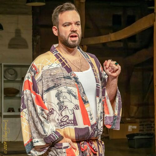 Ein Mann in einem bunten Kimono spricht leidenschaftlich auf der Bühne des Theatervereins. | © Mary Stevens