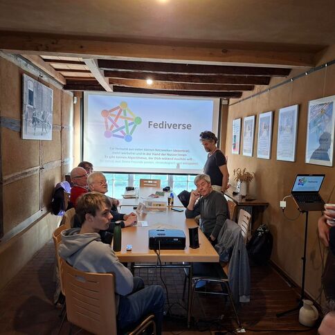 Eine Gruppe von Teilnehmern im Tuppenhof in Kaarst diskutiert über das Projekt Fediverse während einer informativen Besprechung.
