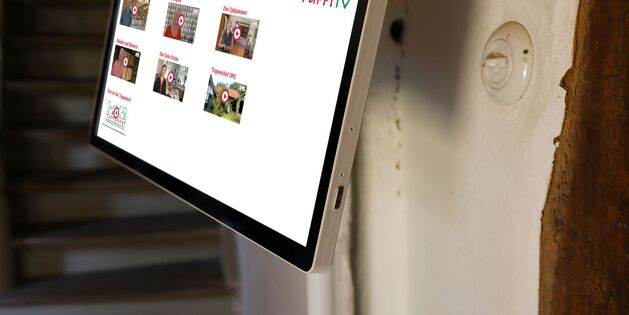 Ein Touchscreen-Display im Tuppenhof zeigt verschiedene Videos und Informationen für Besucher in Kaarst.