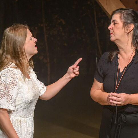 Zwei Frauen stehen in intensiver Diskussion, während sie in einem Theaterstück im Tuppenhof in Kaarst auftreten.