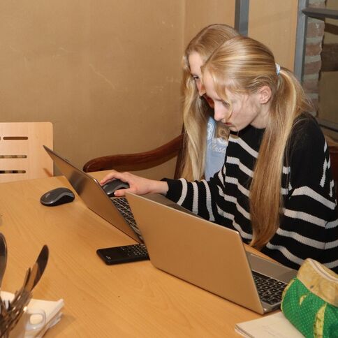 Zwei junge Frauen arbeiten konzentriert an Laptops in einem gemütlichen Raum am Tuppenhof in Kaarst.