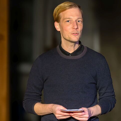 Ein Mann hält eine Rede im Tuppenhof in Kaarst, während er ein kleines Notizbuch in den Händen hält.