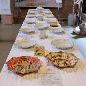 Der festlich gedeckte Tisch im Tuppenhof, Kaarst, zeigt historische Teller und Dekorationen.