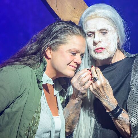 Zwei Frauen stehen auf einer Bühne im Tuppenhof Kaarst, eine mit auffälligem weißen Make-up, in innigem Gespräch.