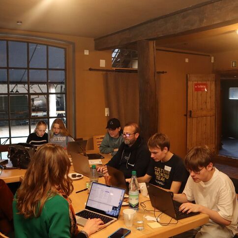 Personen arbeiten konzentriert an Laptops in einem gemütlichen Raum des Tuppenhofs in Kaarst.