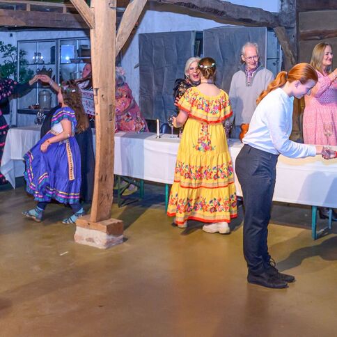 In einem festlichen Raum des Tuppenhofs in Kaarst tanzen und feiern Menschen in bunten Trachten.