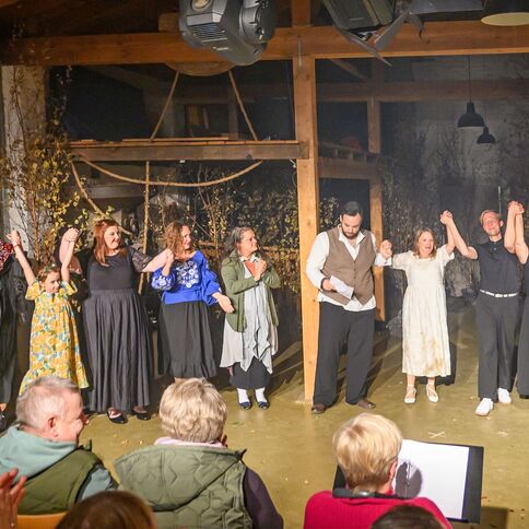 Eine Gruppe von Schauspielern verbeugt sich nach einer Aufführung im Tuppenhof in Kaarst vor applaudierendem Publikum.