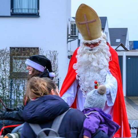 Ein als Nikolaus verkleideter Mann begrüßt fröhlich Besucher beim Tuppenhof in Kaarst.