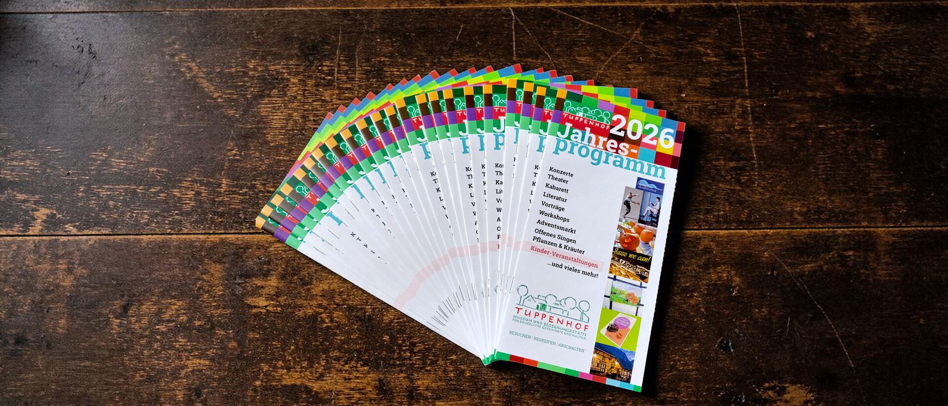 Ein fächerartig angeordnetes Jahresprogramm 2026 des Tuppenhofs in Kaarst zeigt verschiedene Veranstaltungen und Workshops.