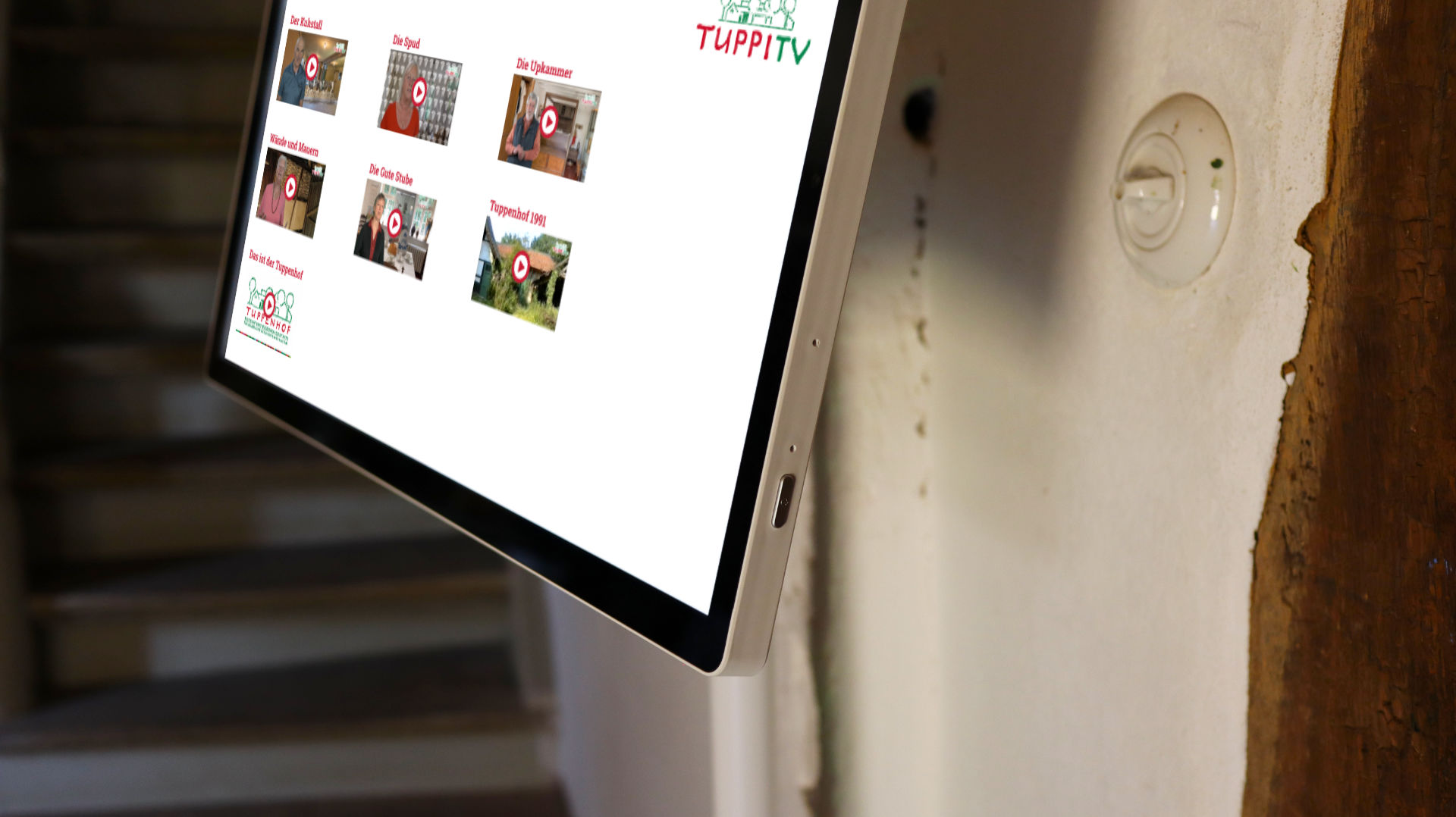 Ein Touchscreen-Display im Tuppenhof zeigt verschiedene Videos und Informationen für Besucher in Kaarst.
